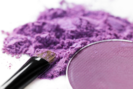 crushed purple eye shadow and makeup brush isolated on white backgroundの写真素材