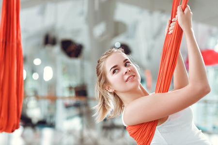 Fly yoga. Young woman practices aerial anti-gravity yoga with hammock .の写真素材