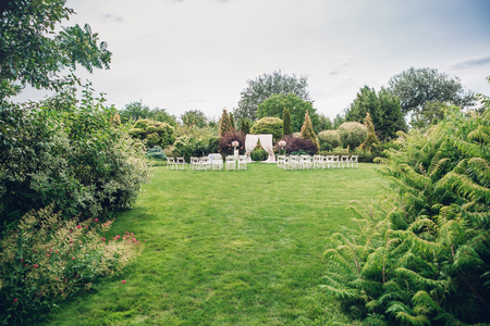 Arch and chairs for the wedding ceremony, decorated with cloth and floral compositionsの写真素材