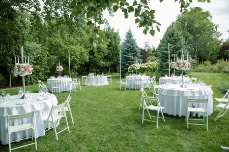 Wedding banquet in the open air, wedding decor on the tables of guestsの写真素材
