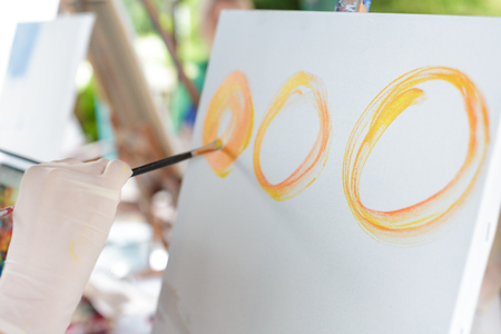 artists hand with brush painting on canvasの写真素材