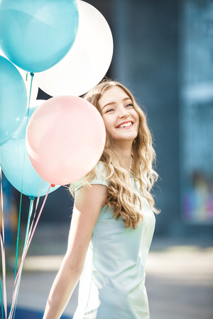 beautiful woman with flying multicolored balloonsの写真素材