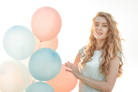 beautiful woman with flying multicolored balloonsの写真素材
