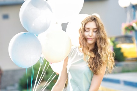 beautiful woman with flying multicolored balloonsの写真素材
