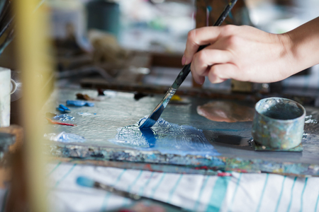 Artist mixes oil paints on palletの写真素材