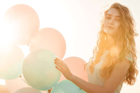 beautiful woman with flying multicolored balloonsの写真素材