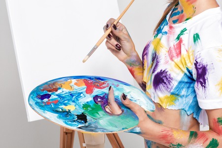female artist holding  palette with paints for drawing
