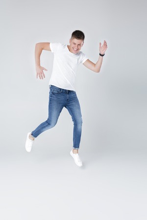 handsome man in jeans and jacket jumping