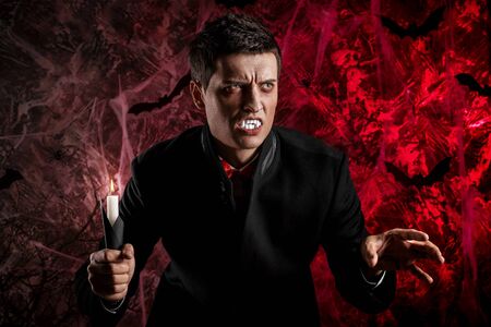 handsome man dressed in a Dracula costume for Halloween.