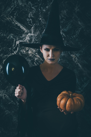 Halloween Witch holding a pumpkinの写真素材