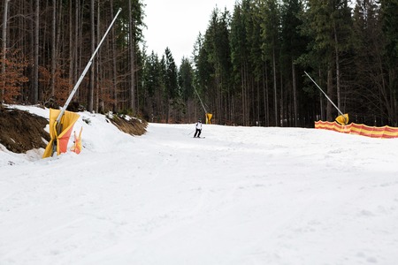 skier is skiing down the slope in the woodsの写真素材