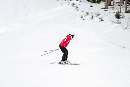 skier is skiing down the slope in the woodsの写真素材
