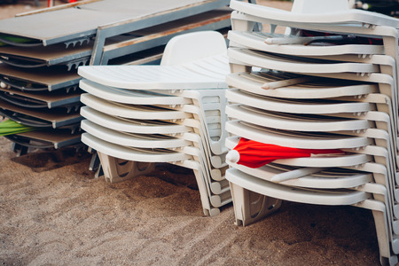 stack of sun loungers at the end of a summer dayの写真素材
