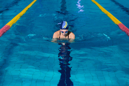 woman swimming with swimming hat in swimming poolの写真素材