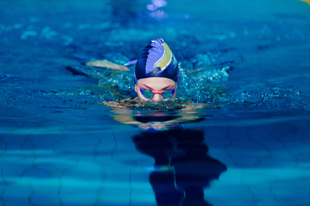 woman swimming with swimming hat in swimming poolの写真素材