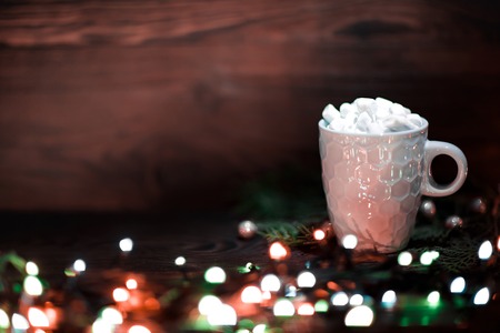 cup of chocolate with marshmallow on dark wooden Christmas background with bokehの写真素材