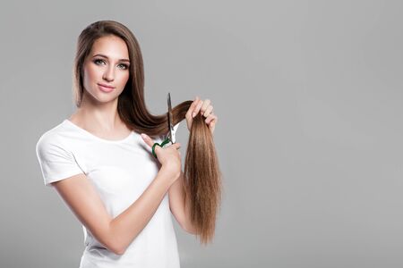 woman with  long hair holds scissorsの写真素材