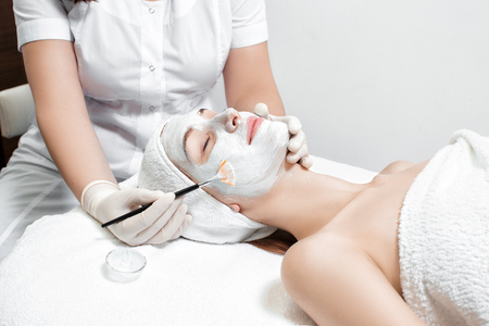 beautician applies mask to the face of  womanの写真素材
