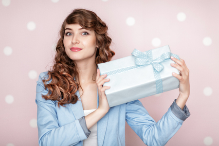 woman in blue jacket holds gift box.の写真素材