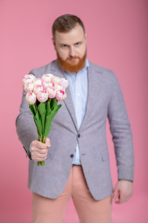 Handsome man holding bouquet of tulipsの写真素材