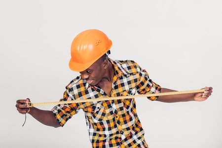 African-American builder uses measuring tapeの写真素材