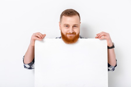 man with beard holding big white card.の写真素材