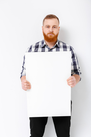 man with beard holding big white card.の写真素材
