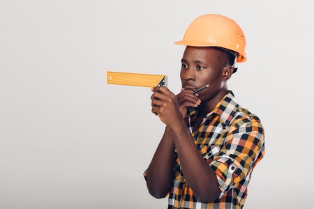 African-American builder uses measuring tapeの写真素材