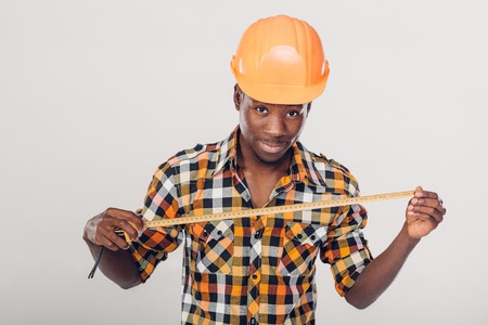 African-American builder uses measuring tapeの写真素材