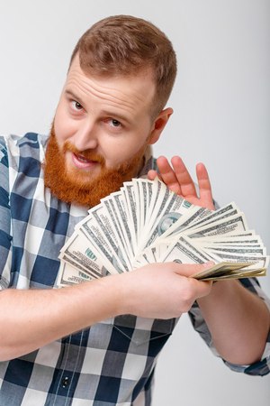 man with beard holding lot of hundred-dollar billsの写真素材