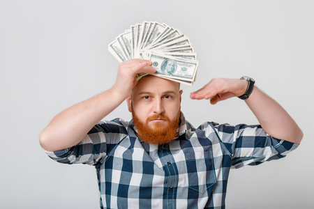 man with beard holding lot of hundred-dollar billsの写真素材