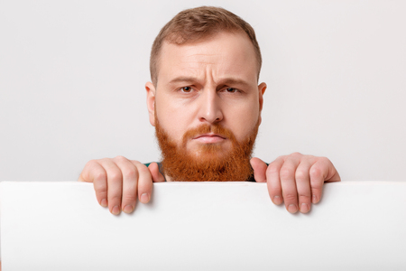 man with beard holding big white card.の写真素材