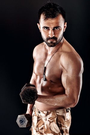 muscular man doing exercises with dumbbells