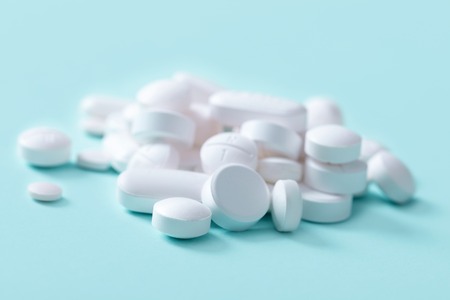 white pills on blue backgroundの写真素材