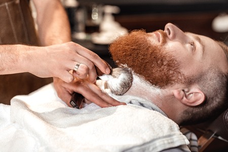 Barber and bearded man in barber shopの写真素材