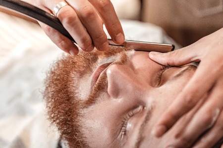 Barber and bearded man in barber shopの写真素材