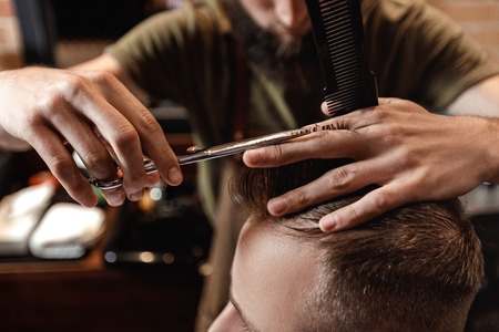 Barber and bearded man in barber shopの写真素材