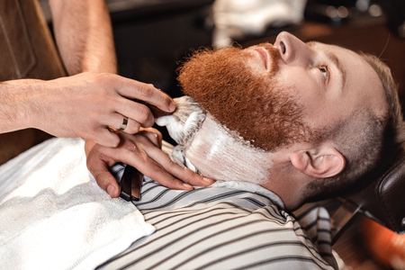 Barber and bearded man in barber shopの写真素材