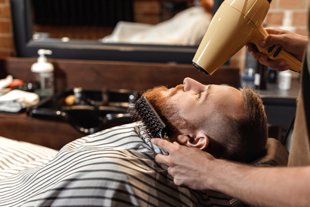 Barber and bearded man in barber shopの写真素材