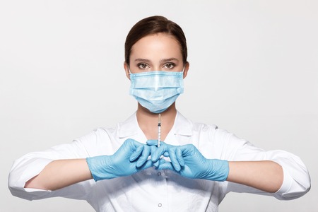 doctor in uniform and gloves with syringe