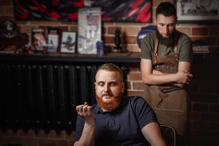 Barber and bearded man in barber shopの写真素材