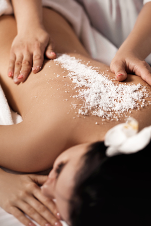 woman receiving massage with salt peelingの写真素材