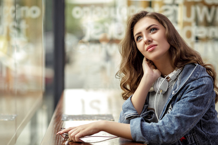 woman sits in a cafe and dreamsの写真素材
