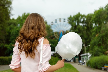 attractive woman holding sweet cotton candyの写真素材