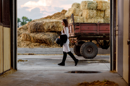 rider woman walks past stable after trainingの写真素材