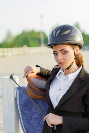 elegant rider woman in helmet with whipの写真素材