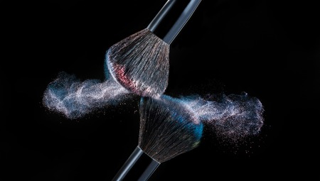 Make up brush with powder splashes on black backgroundの写真素材