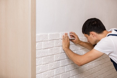 Professional Builder gluing decorative tile on wall.の写真素材