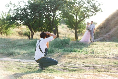 wedding photographer takes pictures of bride and groomの写真素材