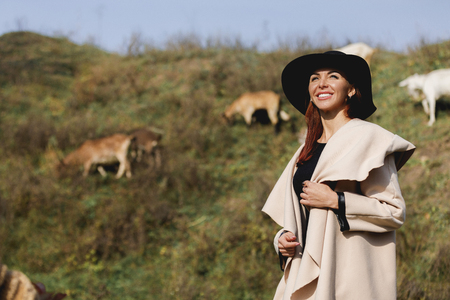 woman in coat and hat on sunny autumn dayの写真素材